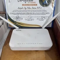 The donated Wi-Fi router in front of the precinct&rsquo;s certificate of award