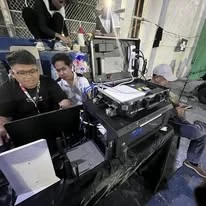 A TINKIT technician at a laptop beside the portable network kit