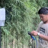 A TINKIT technician testing the connection beside an access point