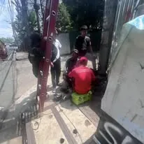 A ladder against a utility pole with the crew working at its base