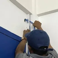 A technician securing a network cable along a door frame