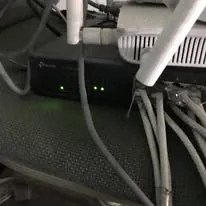 A network switch and a Wi-Fi router with their lights on